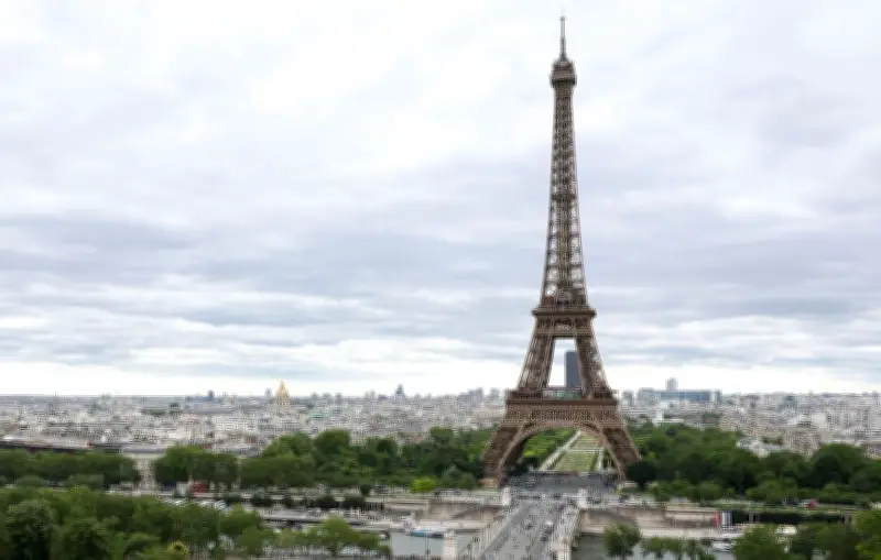 Un homme escalade la tour Eiffel et accroche un drapeau américain