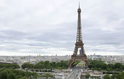 Un homme escalade la tour Eiffel et accroche un drapeau américain
